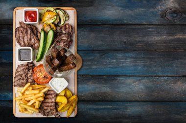 Bira aperatifler küme. Et küme kesme tahtası ahşap arka plan ile servis.