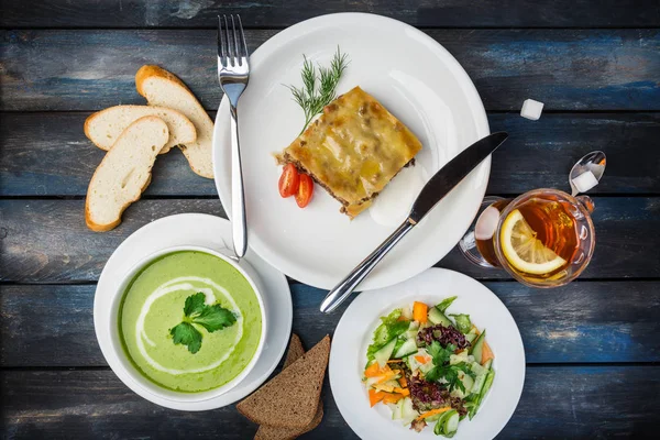 Almoço preparado. Lasanha, sopa e legumes salada fresca, servida com os talheres . — Fotografia de Stock