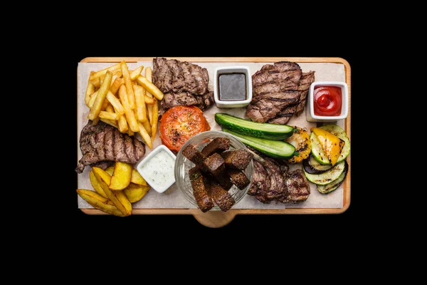 Bira aperatifler küme. Et küme kesme tahtası, siyah arka plan üzerine izole yılları arasında görev yapmıştır.