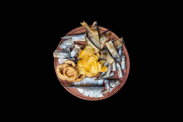 Bira aperatifler küme. Tuzlanmış, kurutulmuş balık, kalamar halkaları ve patates cipsi, kesme tahtası üzerinde hizmet.