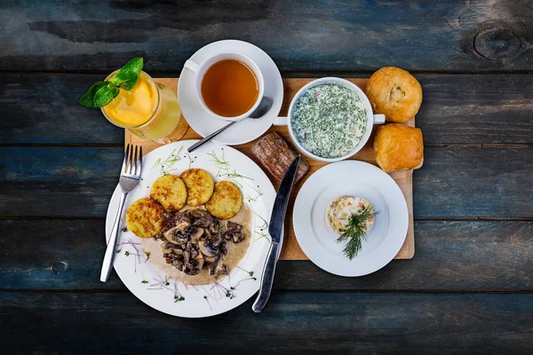 Lunch set. Okroshka, mushroom with hashbrowns and traditional russian salad, served on the tray with the cutlery. — Stock Image Lunch set. Okroshka, mushroom with hashbrowns and traditional russian salad, served on the tray with the cutlery. Royalty Free Stock Photos