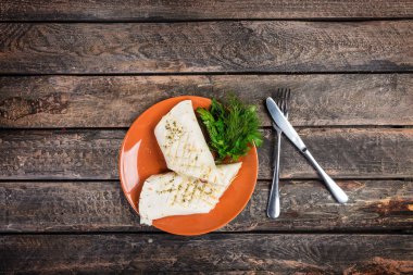 Tavuk göğsü ve seramik bir tabakta sebze tortilla sarın. Çatal bıçak takımı ahşap zemin ile servis.