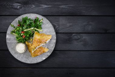 Strudel tavuk, kabak ve sebze salatası, seramik plaka üzerinde hizmet.