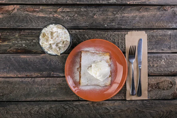 Strudel com um sorvete de maçã e baunilha, servido na placa de cerâmica com os talheres e o copo de bebida . — Fotografia de Stock