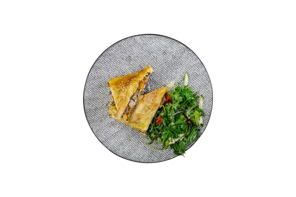 Штрудель з тушкованою капустою, м'ясом та овочевим салатом, подається на керамічній тарілці . — стокове фото
