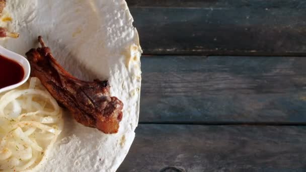 Lombo di agnello spiedino fatto di pezzi di carne e verdura shish con cipolle su pita vicino. Ruota su uno sfondo di legno. Vista dall'alto con lo spazio di copia per il testo . — Video Stock