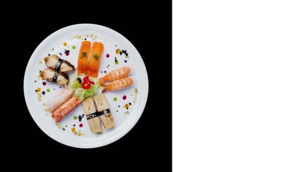 Sashimi conjunto giratorio en un plato redondo blanco, decorado con flores pequeñas, comida japonesa. Vista superior. Aislado sobre un fondo negro. Diseño cuadrado para redes sociales, espacio de copia para su texto — Vídeos de Stock