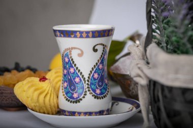 Armudu beyaz cam mavi bir buta üzerinde mavi bir çerçeve ve bisküvi ile beyaz bir daire şeklinde yazdırma.