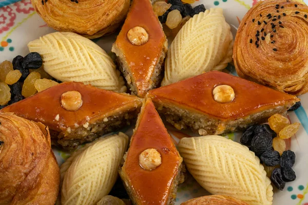Festival acentelerin tatil için pişirme. Shekerbura, baklava, beyaz ve siyah kuru üzüm ile bir tabakta tuzlu dolgulu puf böreği.