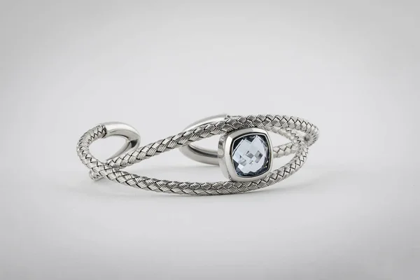 Kvinnliga, silver, flätad ring med ljus blå sten i mitten, isolerad på vit bakgrund. — Stockfoto