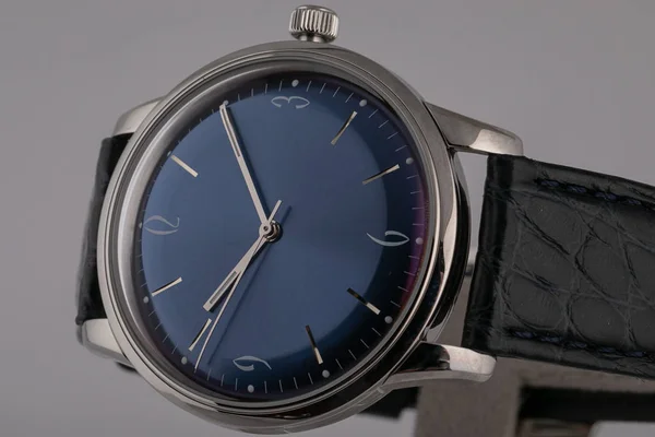 Reloj de los hombres con correa de cuero negro, esfera azul, en cuerpo de plata, gris en el sentido de las agujas del reloj y números aislados sobre fondo gris . — Foto de Stock