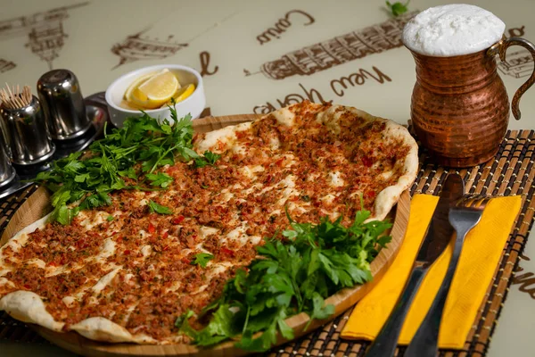 Hamur kek eti, limon ve yeşillik kahverengi yazıtlı bir beyaz masa örtüsü ile bir tabloda bir ahşap plaka üzerinde.