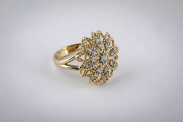 Kvinnors Guldring med diamanter i form av blomma i mitten, isolerad på vit bakgrund. — Stockfoto