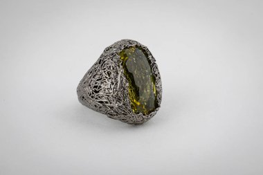 Beyaz bir arka plan üzerinde izole bir dikdörtgen şeklinde orta yeşil taşlı yüzükler kadın, gümüş hasır.