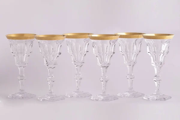 Stemware faceted glasses made of Czech glass with a Golden ornament isolated on a white background. — Stock Photo, Image