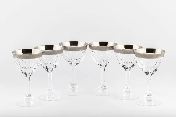 Calici sfaccettati bicchieri di vetro ceco con un ornamento d'argento isolato su uno sfondo bianco . — Foto Stock
