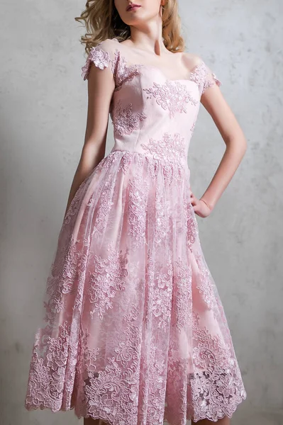 Dziewczyna w różowej sukience, off ramieniu, z haftem w kształt kwiaty na białym tle na szarym tle. — Zdjęcie stockowe