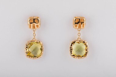 Beyaz arka planda izole açık sarı elmas ile altın kadın küpe