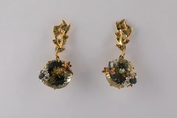 Gold Frauen Ohrringe aus Roségold in Form von Kreisen mit Diamanten und Figuren darauf isoliert auf weißem Hintergrund. — Stockfoto