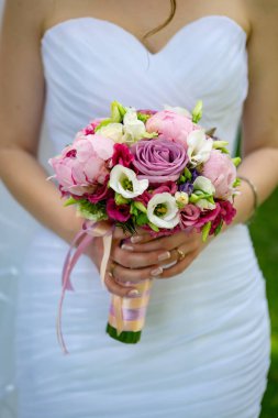 Elinde gül bir düğün buket ile beyaz bir gelinlik gelin.