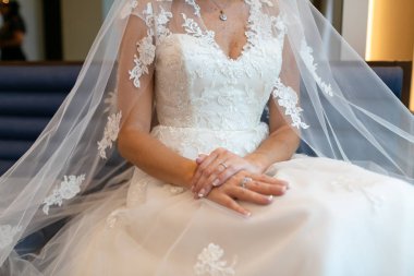 Gelin bir peçe ile bir gelinlik oturan.