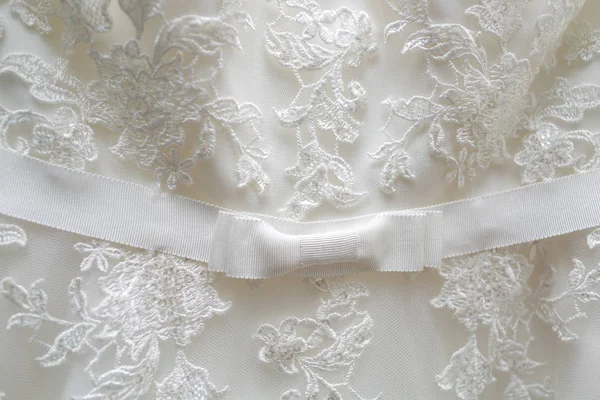 Materiale tulle bianco con motivi a forma di fiori e un fiocco al centro . — Foto Stock