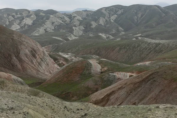 丘と山が空に向かって斜面に赤い縞模様で覆われている. — ストック写真