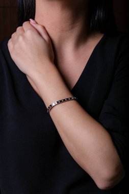 Siyah bir arka plan üzerinde taş ile eldeki gümüş kadın bilezik.