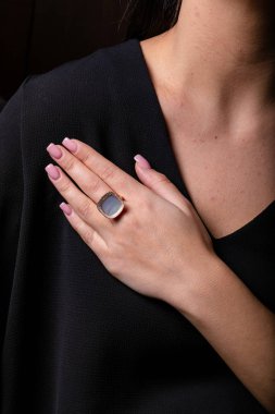 Elmaslı altın bir yüzük. Ortasında taşlar var. Siyah bir arka planda..