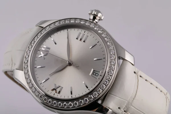 Reloj de plata hembra con esfera gris claro, plateado en el sentido de las agujas del reloj, cronógrafo, con una correa de cuero blanco aislado sobre fondo blanco — Foto de Stock