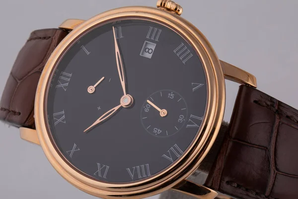 Złoty zegarek na rękę z czarną cyferblat, złoty w prawo, stoper i chronograf na brązowym skórzanym pasku na białym tle — Zdjęcie stockowe