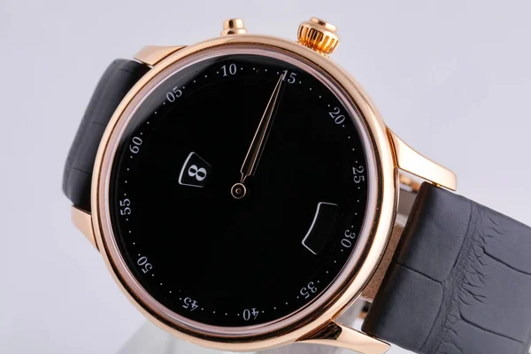 Gyllene armbandsur med svart urtavla, svart medurs, kronograf på svart läderrem på vit bakgrund — Stockfoto