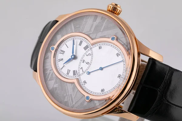 2つの白いダイヤルを持つ金色の腕時計、白い背景に隔離された黒い革のストラップに時計回りに青い — ストック写真