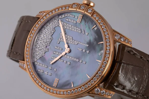 Relógio de pulso dourado feminino com mostrador azul com pedras, dourado no sentido horário em pulseira de couro marrom isolado no fundo branco — Fotografia de Stock