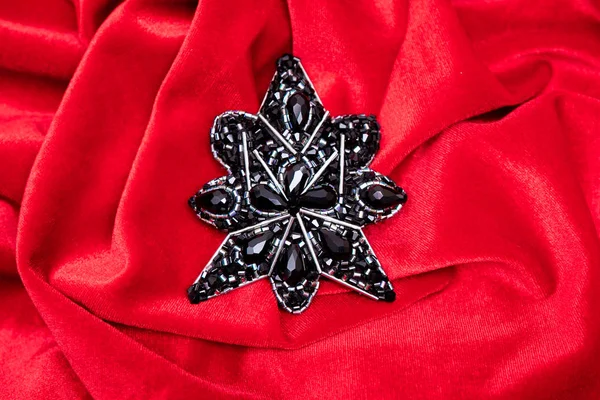 Broche de designer feito de jóias artesanais isoladas em um fundo vermelho . — Fotografia de Stock