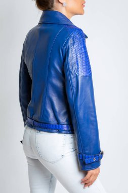 Uzun kollu, mavi, askılı ve demir kilitli kadın deri ceket.