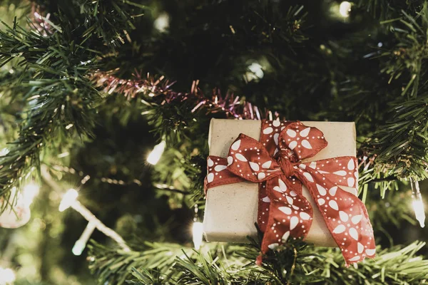 リボンと照明 クリスマスの背景 レトロなフィルターと松の木にクリスマス ギフト ボックスを閉じる — ストック写真
