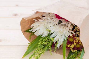 Doğal ahşap zemin üzerine pembe gül, beyaz carnationand kırmızı krizantem çiçekli güzel buket