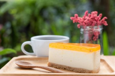 Ahşap tepsi ve t Passion meyve cheesecake ve sıcak kahve fincanı