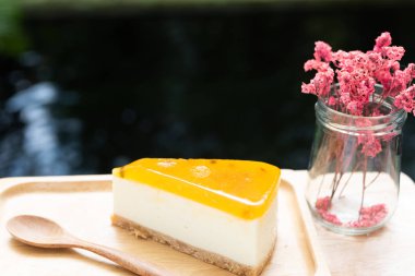 Passion meyve cheesecake ahşap tay ve ahşap masa üzerinde hizmet