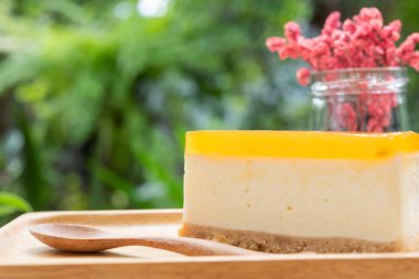 Passion meyve cheesecake ahşap tay ve ahşap masa üzerinde hizmet