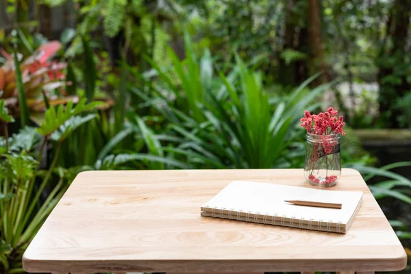 Cuaderno, lápiz marrón y hermosa flor roja seca en vidrio va — Foto de Stock