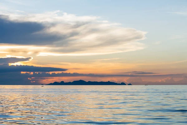 Закат на пляже с синим морем и облаком золотистого света — стоковое фото
