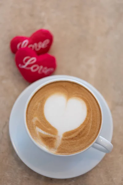 Hot coffee cup with red hearts shape symbol on marble table  bac — Stock Photo, Image