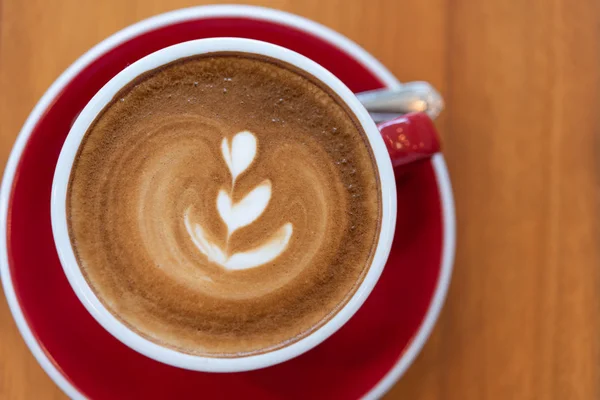 Hot coffee cup with latte art  in red cup on wood background,fla — Stock Photo, Image