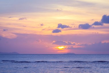 Mavi deniz ve altın ışık gökyüzü bulutu ile güzel plaj gün batımı