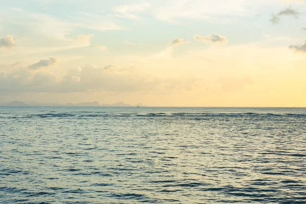 Mavi deniz ve altın ışık gökyüzü bulutu ile güzel plaj gün batımı — Stok fotoğraf