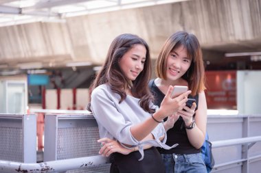 Online seyahat için cep telefonu kullanarak iki kadın güzel arkadaşlar 