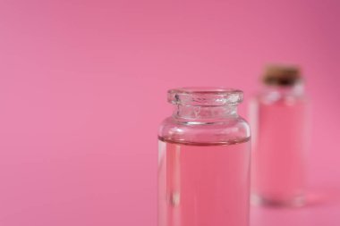 Pembe arka planda gül sıvı şişe