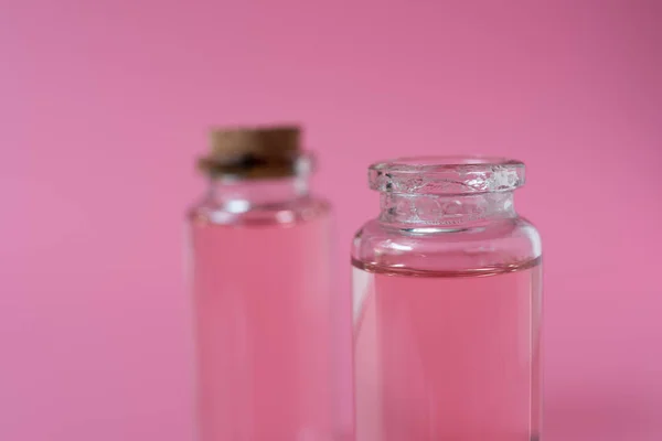 Рожева пляшка рідини на рожевому фоні — стокове фото